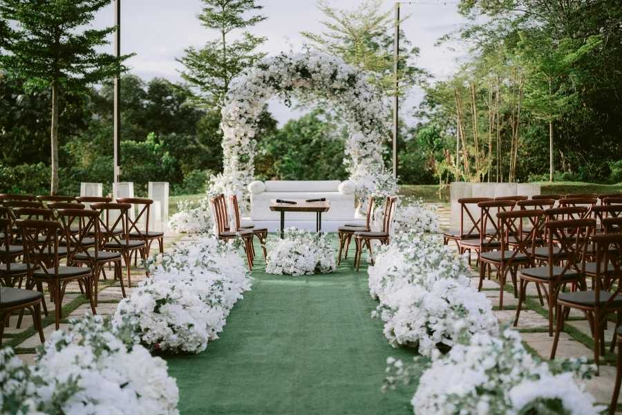 An outdoor wedding ceremony setup with white floral arrangements to plan a micro-wedding
